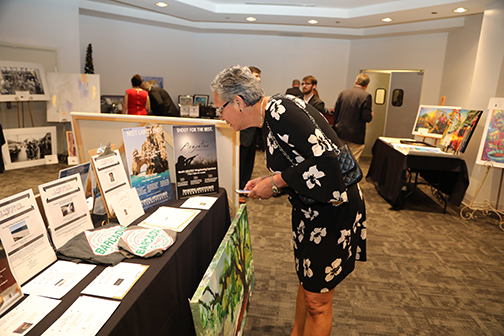 Dr. Patricia Molina chekcing out silent auction items at Camp Tiger Benefit Auction 